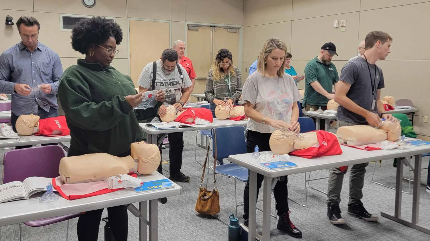 a friendly nurse instructor calmly coaching an adult student during CPR skills verification, Lafayette Louisiana, Cajun South Louisiana feel, professional training classroom, mannequins and AED trainers visible